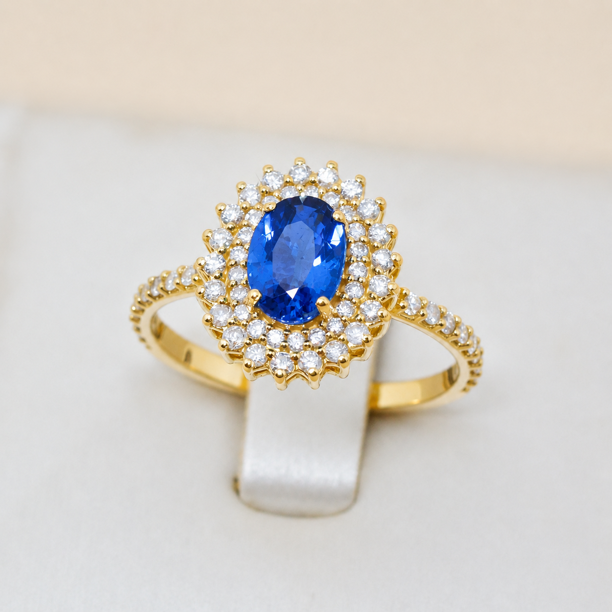 Anel em Ouro 18k com pedra oval sintética rosa e halo de zircônias brancas.
